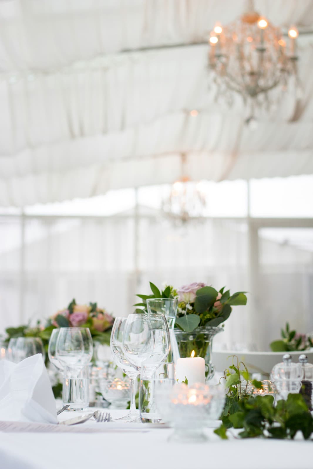 Candlelit reception table with flowers and chandeliers